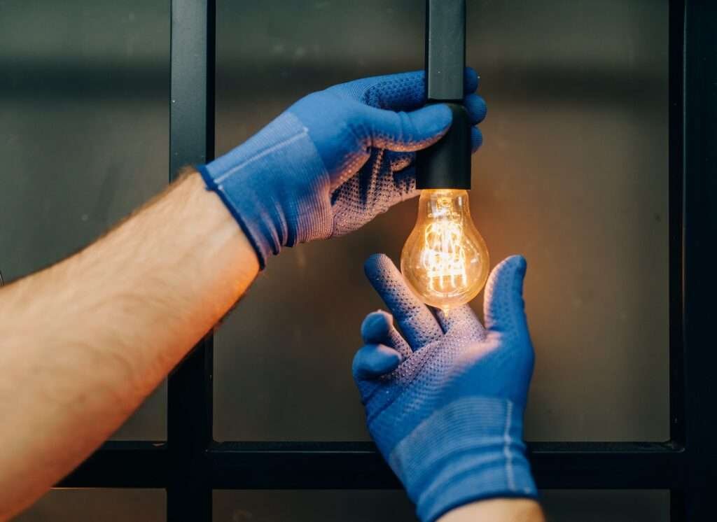 electrician changes the light bulb handyman